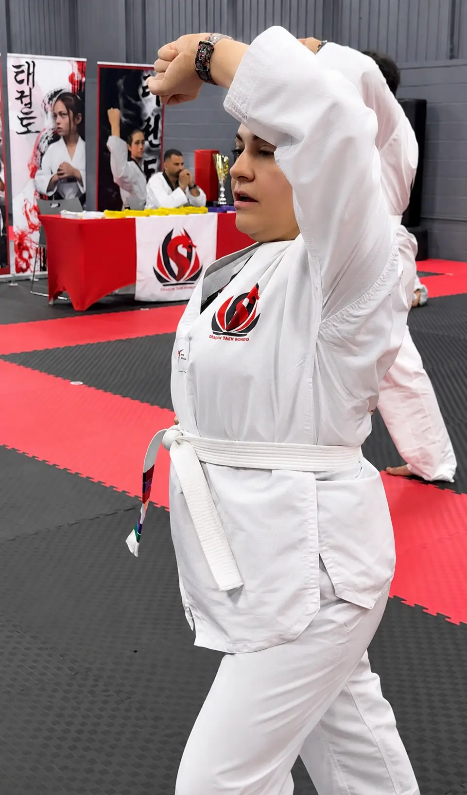 An adult student with a white belt practising a block