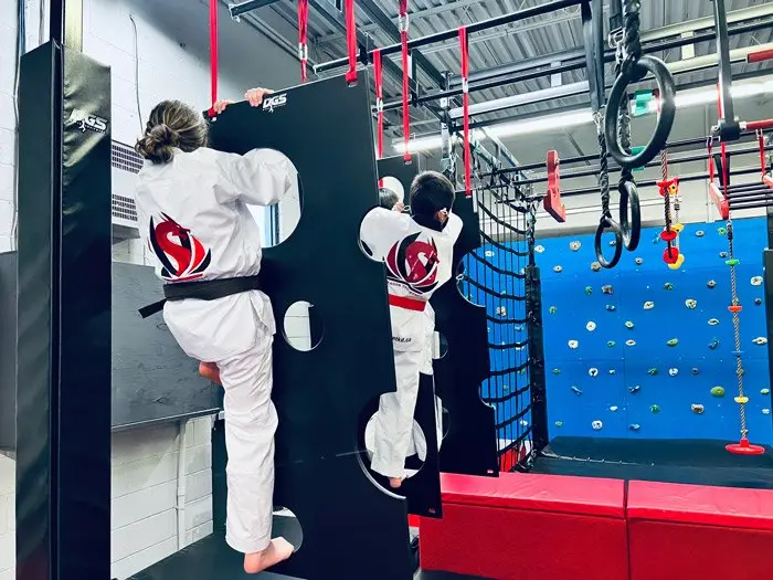 A student on the holey wall next to the rings
