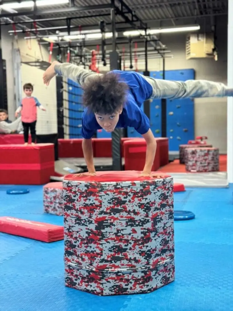A child jumping over the pads on the Dragon Taekwondo indoor ninja course