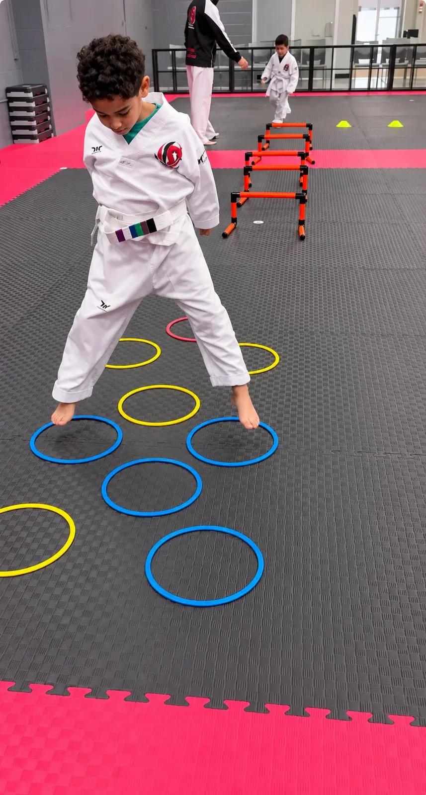 A Dragon Taekwondo student doing a footwork drill through agility rings