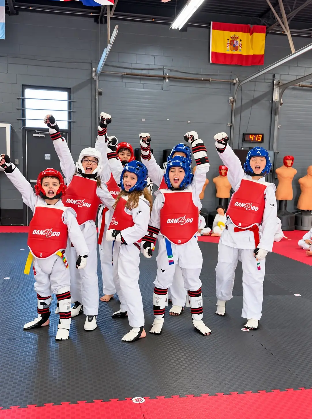 Young Dragon Taekwondo students in helmets and chest protectors cheering