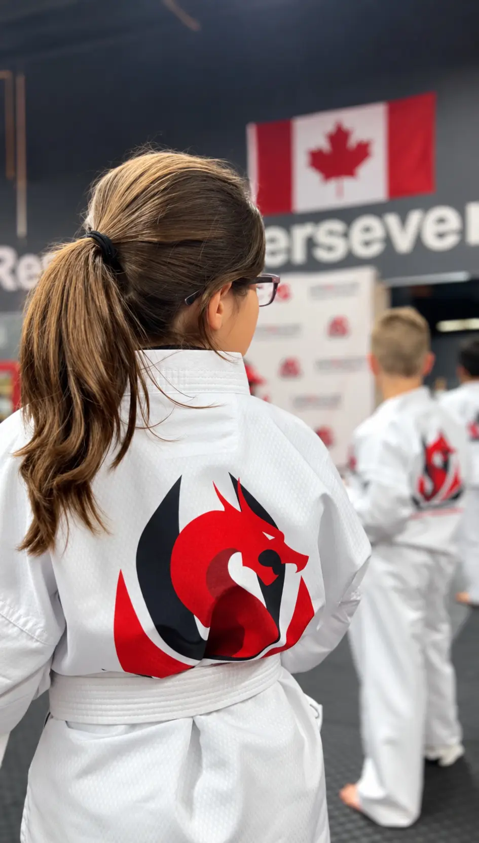 A student with the Dragon Taekwondo logo on the back of her uniform