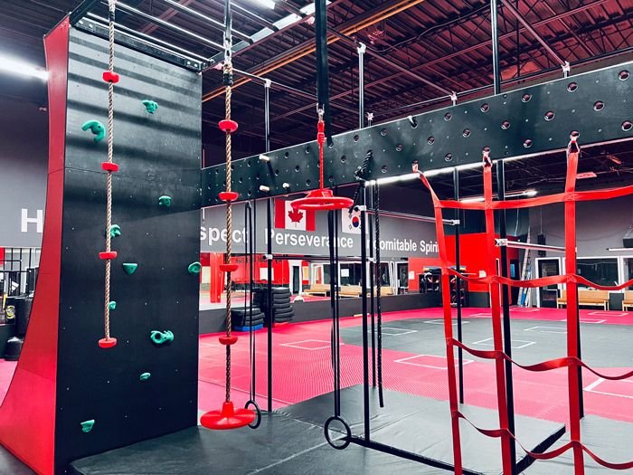 The climbing wall and ninja frame in the Oakville training hall